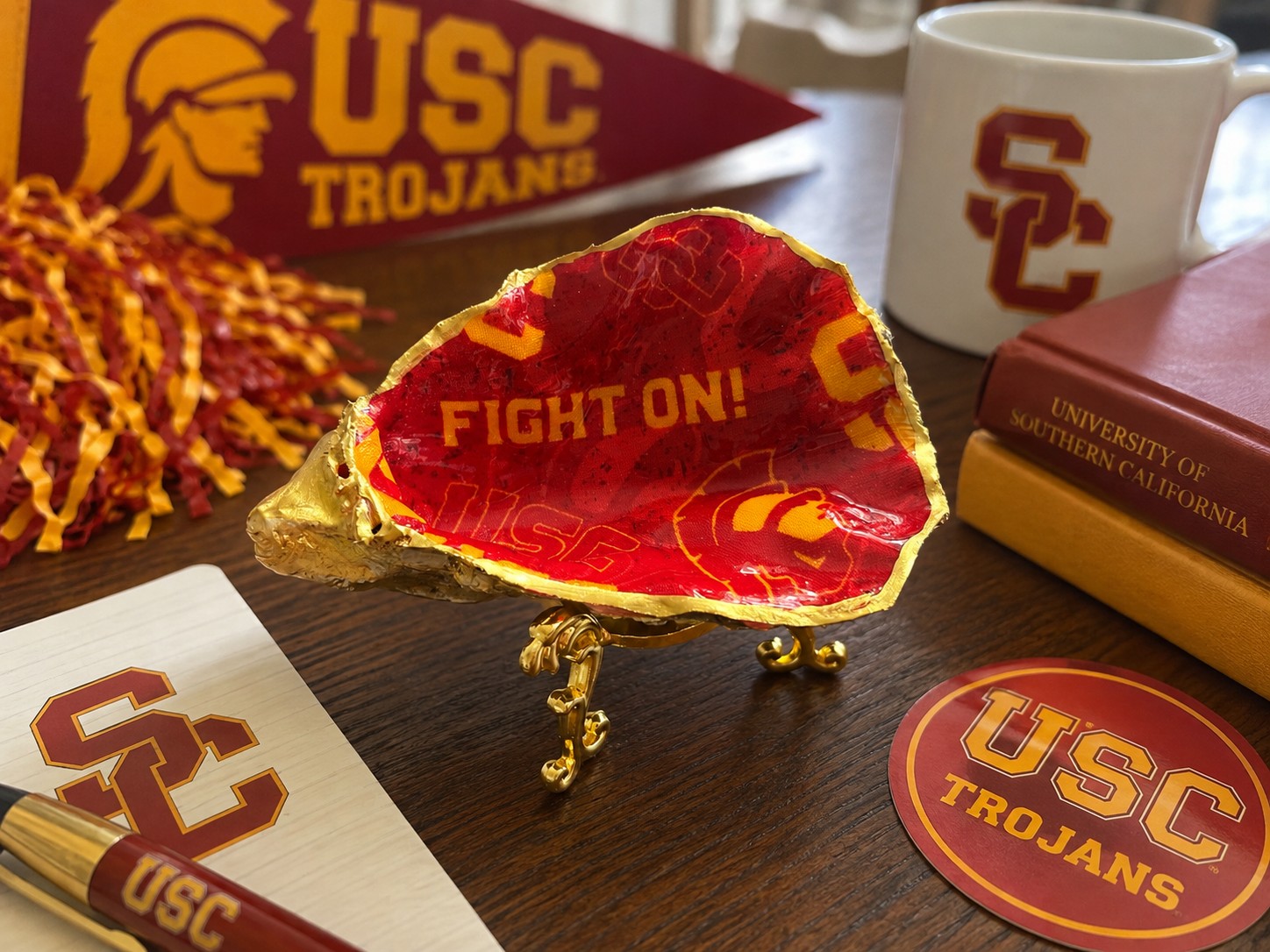 Red and gold USC-themed oyster shell on a decorative stand